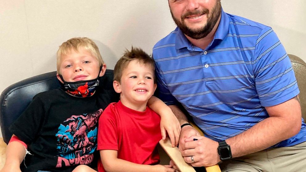 From left, 7-year-old Russell Bright, 5-year-old Tucker Bright, and dad Adam Bright pose for a picture at Ochsner Medical Center in Jefferson, La., Monday, June 7, 2021. Tests of Pfizer’s COVID-19 vaccine started Monday in Louisiana for children ages