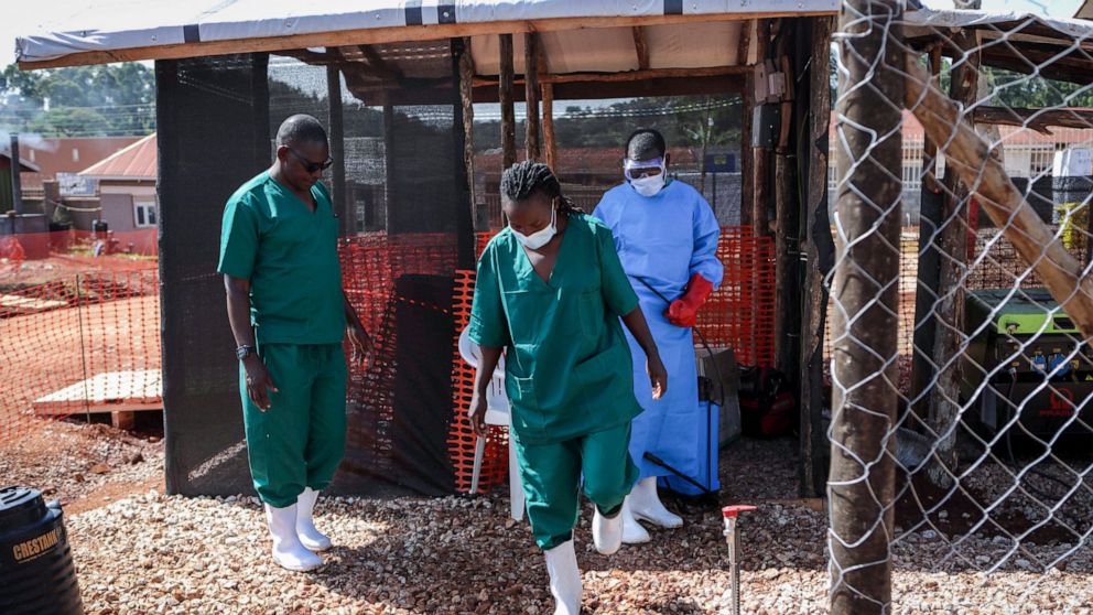 A medical attendant disinfects the rubber boots of a medical officer before leaving the Ebola isolation section of Mubende Regional Referral Hospital, in Mubende, Uganda Thursday, Sept. 29, 2022. In this remote Ugandan community facing its first Ebol
