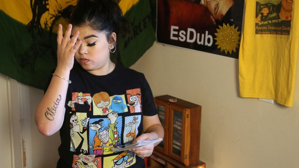 Seanna Leilani Chavez, the sister of Aaron Francisco Chavez, pauses as she looks at family photos as she stands next to a shrine for Aaron, including images of Aaron on the wall, at the family home Wednesday, Feb. 6, 2019, in Tucson, Ariz. Aaron Chav