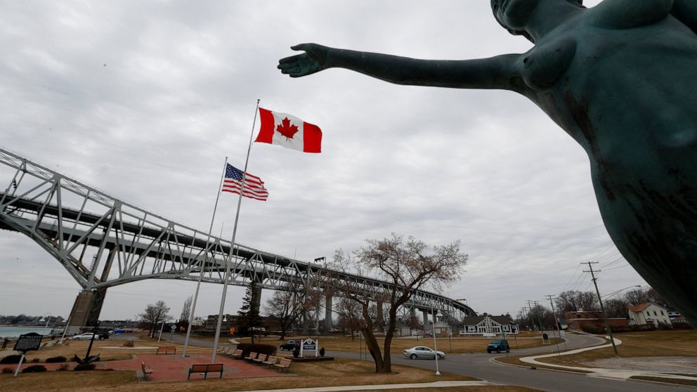The Blue Water Maiden statue stands at the base of the Blue Water Bridge in Port Huron, Mich., which connects to Sarnia, Ontario, Canada, Wednesday, March 18, 2020. The Canada-U.S. border will be closed to non-essential traffic in both directions "by