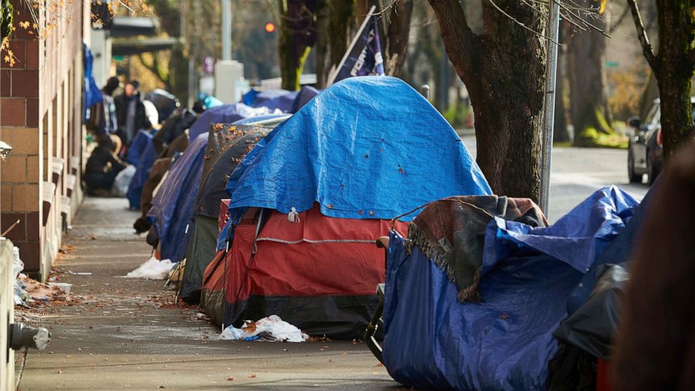 FILE - Tents line the sidewalk on SW Clay St in Portland, Ore., on Dec. 9, 2020. Portland Mayor Ted Wheeler announced this morning Friday, Oct. 21, 2022, that the city will ban homeless street camping in the coming months as it creates new, large "de