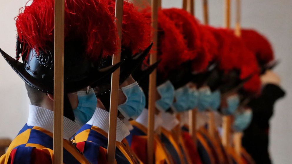 FILE - In this Saturday, Oct. 24, 2020 file photo, Vatican Swiss Guards wear masks to curb the spread of COVID-19 as they stand attention at the Vatican. Three Vatican Swiss Guards who have refused to be vaccinated against COVID-19 upon Holy See orde