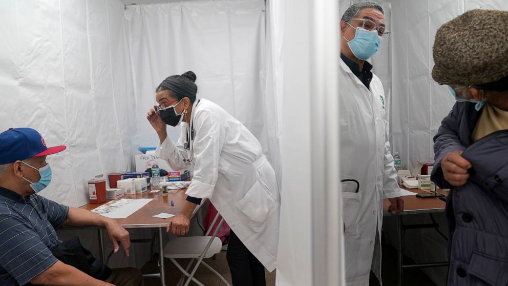 Dr. Ingrid Felix-Peralta, second from left, and her husband Dr. Victor Peralta, second from right, administer second doses of the COVID-19 vaccine in New York, Friday, Feb. 5, 2021. From elderly Cuban Americans in Florida to farmworkers in California
