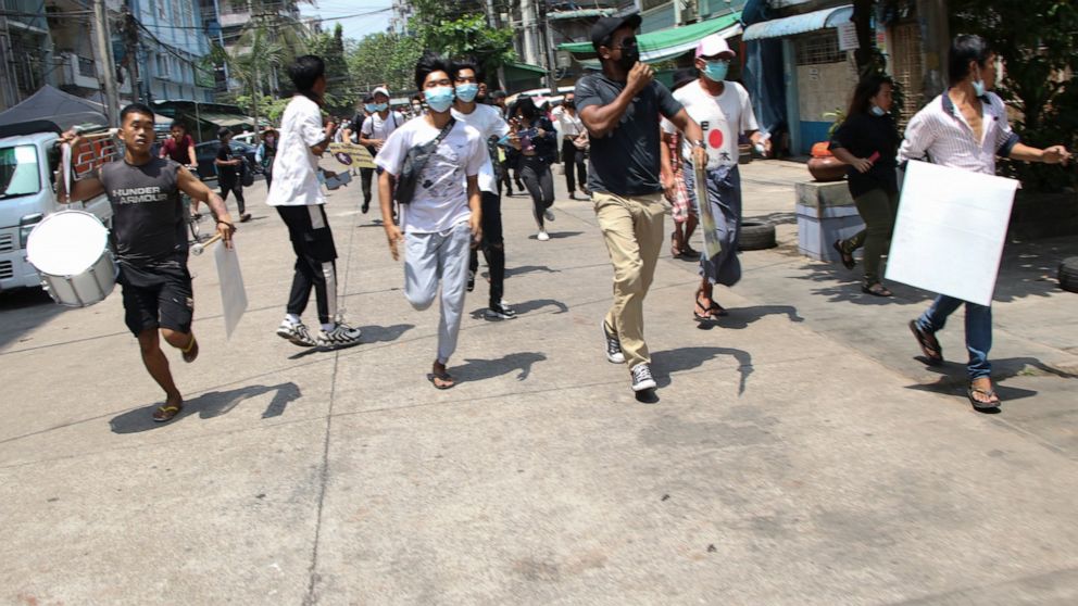Anti-coup protesters run to avoid military forces during a demonstration in Yangon, Myanmar on Wednesday March 31, 2021. A military and police crackdown on protesters in Myanmar may be driving more people across the border between China and Maynmar, 