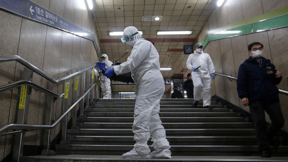 Workers wearing protective gears spray disinfectant as a precaution against the coronavirus at a subway station in Seoul, South Korea, Friday, Feb. 21, 2020. South Korea on Friday declared a "special management zone" around a southeastern city where 