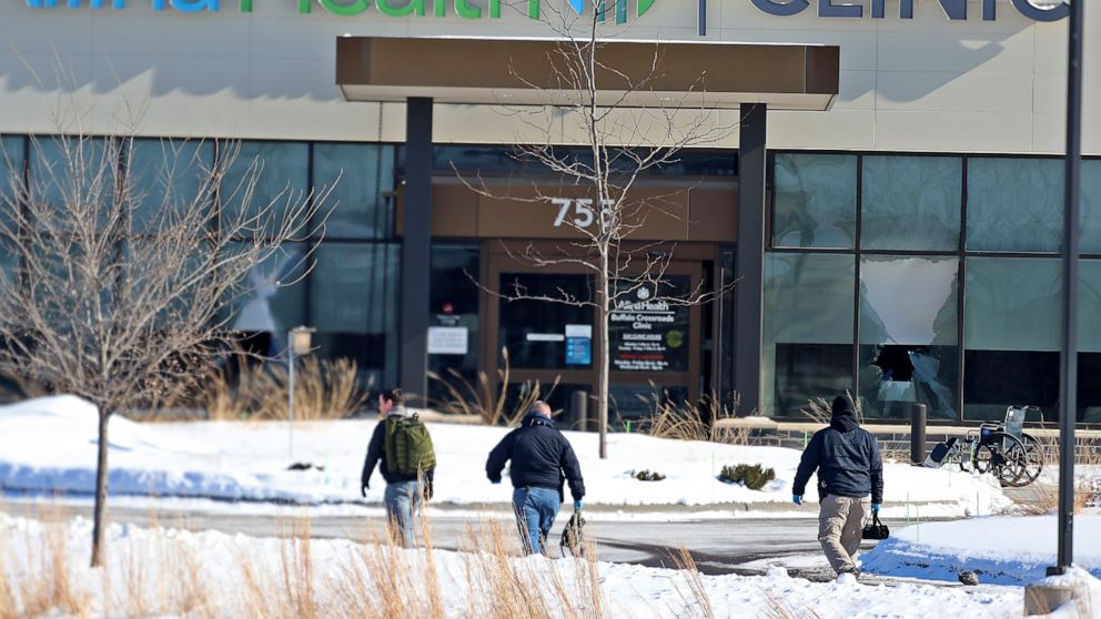 FILE - In this Tuesday, Feb. 9, 2021 file photo, law enforcement personnel walk toward the Allina Health clinic where multiple people were shot in Buffalo, Minn. Doctors say they're facing increasing threats of violence for refusing to prescribe opio