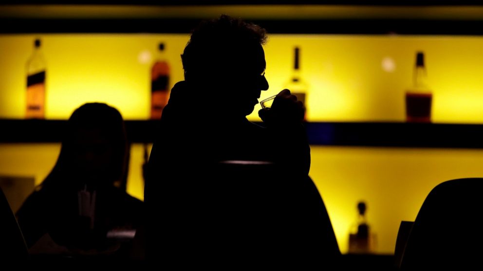 FILE - In this Nov. 30, 2017 photo, a patron sips his drink while having a meal at a bar in New Jersey. More government data points to alcohol's increasing role in U.S deaths, including a new report that found that the alcohol-induced death rate rose