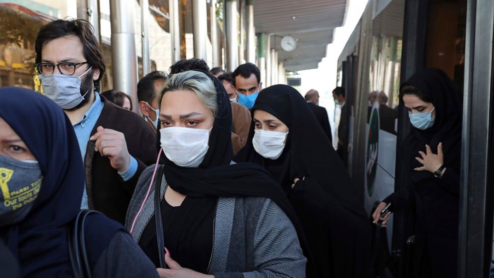 FILE - In this Oct. 11, 2020, file photo, people wear protective face masks to help prevent the spread of the coronavirus in downtown Tehran, Iran. Iran's campaign to inoculate its population against the coronavirus and promote itself as an emerging 