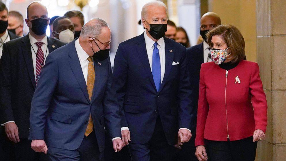 FILE - President Joe Biden is flanked by Senate Majority Leader Chuck Schumer of N.Y., left, and House Speaker Nancy Pelosi of Calif., right, after arriving on Capitol Hill in Washington, Jan. 6, 2022. Biden will give his State of the Union address t