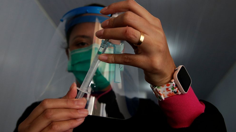 A health worker prepares a shot of the Johnson & Johnson COVID-19 vaccine at the Solidary Hands Shelter for the homeless in the poor neighborhood of Ceilandia in Brasilia, Brazil, Tuesday, June 29, 2021. (AP Photo/Eraldo Peres)
