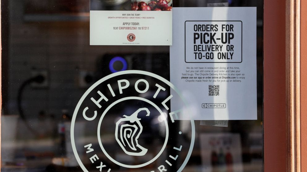 A sign hangs in the window at Chipotle Mexican Grill, Monday, March 16, 2020, in Woodmere Village, Ohio. All bars and restaurants in Ohio will be closed until further notice, said Gov. Mike DeWine, who is taking a tough stance on trying to stem the c