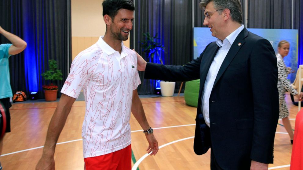 In this photo taken on Saturday June 20, 2020 and provided by the Croatian Tennis Association, Croatian Prime Minister Andrej Plenkovic, right, greets Serbian tennis player Novak Djokovic at a tournament in Zadar, Croatia. Top-ranked tennis player No