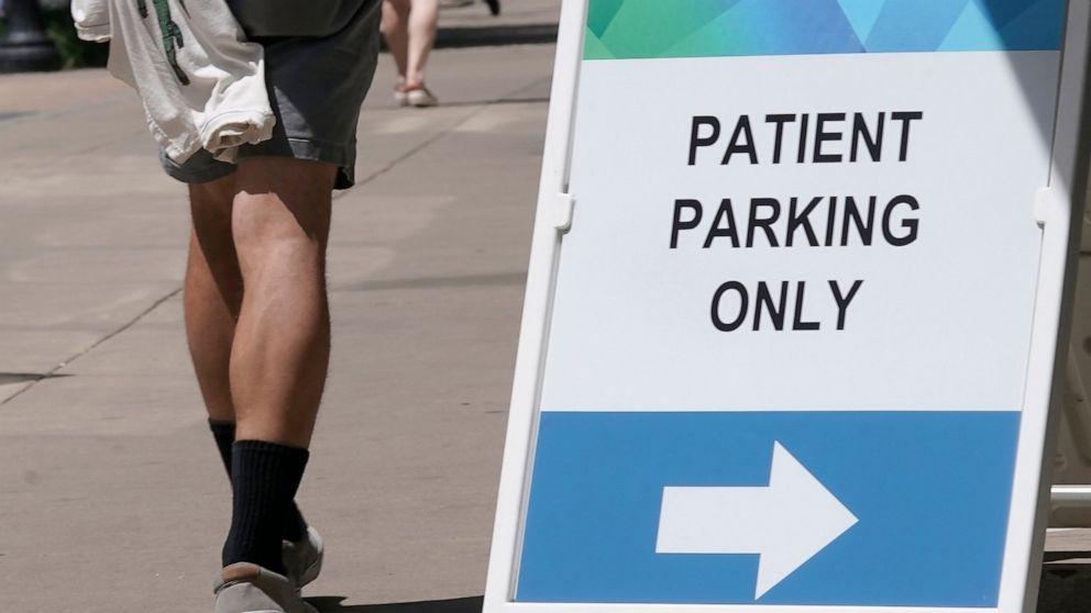 FILE— A sign directing where patients can park is displayed outside a medical facility in Sacramento, Calif., Wednesday, April 27, 2022. California lawmakers approved a bill, Thursday, May, 12, 2022, that would increase the amount of money people in 