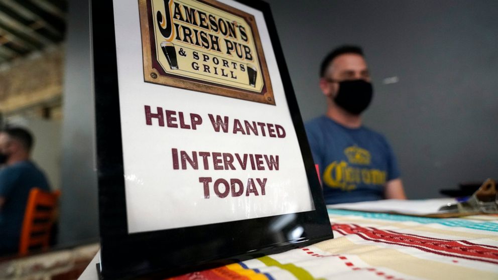 FILE - A hiring sign is shown at a booth for Jameson's Irish Pub during a job fair on Sept. 22, 2021, in the West Hollywood section of Los Angeles. Hiring in California slowed significantly in November 2021 even as the state's unemployment rate dippe