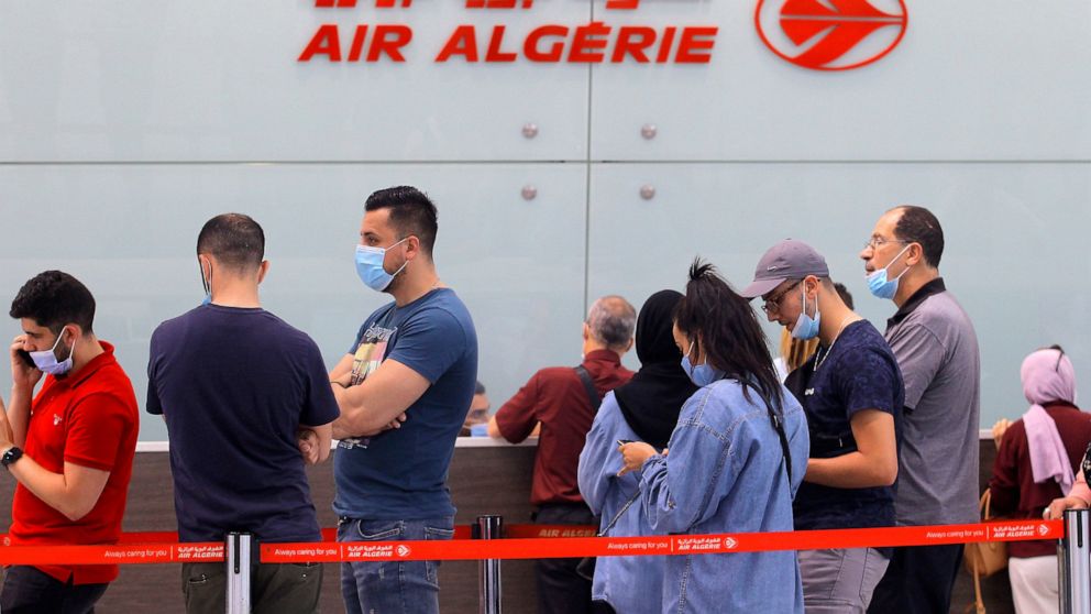 Travelers queue at the Houari Boumediene airport for a flight bound to Paris, Tuesday, June 1, 2021 in Algiers. Algeria has partially reopened its air borders Tuesday for the first time in over 15 months of the COVID-19 crisis. (AP Photo/Fateh Guidoum)
