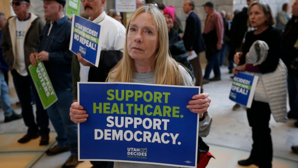 FILE - In this Jan. 28, 2019, file photo, Bonnie Bowman, a supporter of a voter-approved measure to fully expand Medicaid, gathers with others during a rally at the Utah state Capitol, urging lawmakers not to change the law. President Donald Trump's 