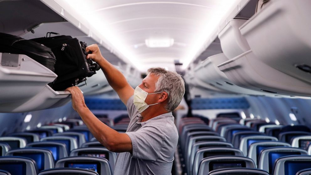 FILE - In this May 28, 2020, file photo, a passenger wears personal protective equipment on a Delta Airlines flight after landing in Minneapolis, United States of America. The European Union Aviation Safety Agency said Wednesday that from next week o