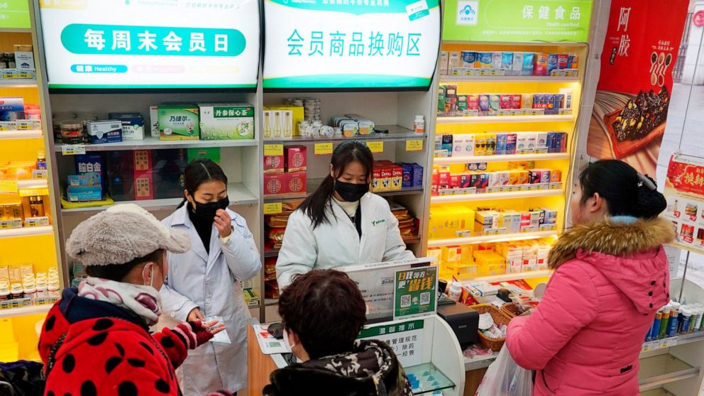 Staff sell masks at a Yifeng Pharmacy in Wuhan, Chin, Wednesday, Jan. 22, 2020. Pharmacies in Wuhan are restricting customers to buying one mask at a time amid high demand and worries over an outbreak of a new coronavirus. The number of cases of the 