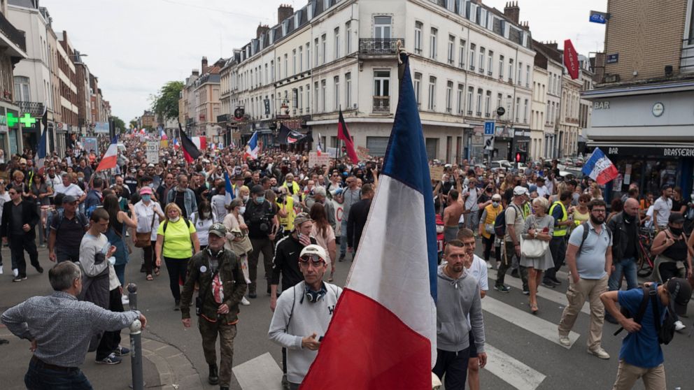 Demonstrators march in Lille, northern France, Saturday, Aug. 21, 2021, during a rally against the COVID-19 health pass needed to access restaurants, long-distance trains and other venues. (AP Photo/Michel Spingler)