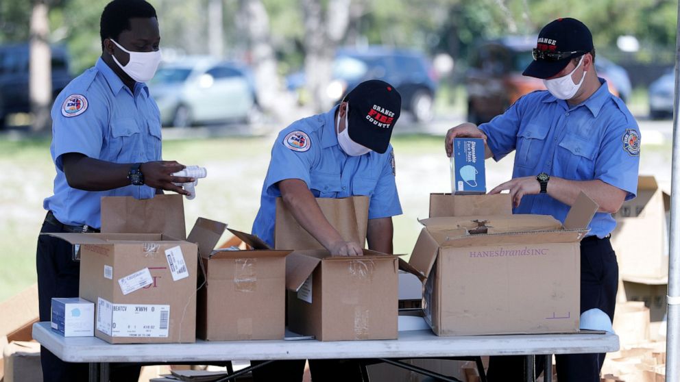 Members of Orange County Fire Rescue pack personal protective equipment (PPE) items including disposable face masks, reusable masks and hand sanitizer in bags to be handed out to small businesses, Wednesday, June 24, 2020, in Orlando, Fla. Because of