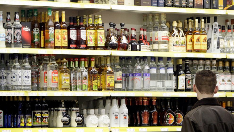 FILE - A young man stands in front of a shelve with hard liquor at a beverage market in Gelsenkirchen, western Germany, June 15, 2007. The German government's drugs czar has proposed raising the age when people can buy beer and win from 16 to 18, and