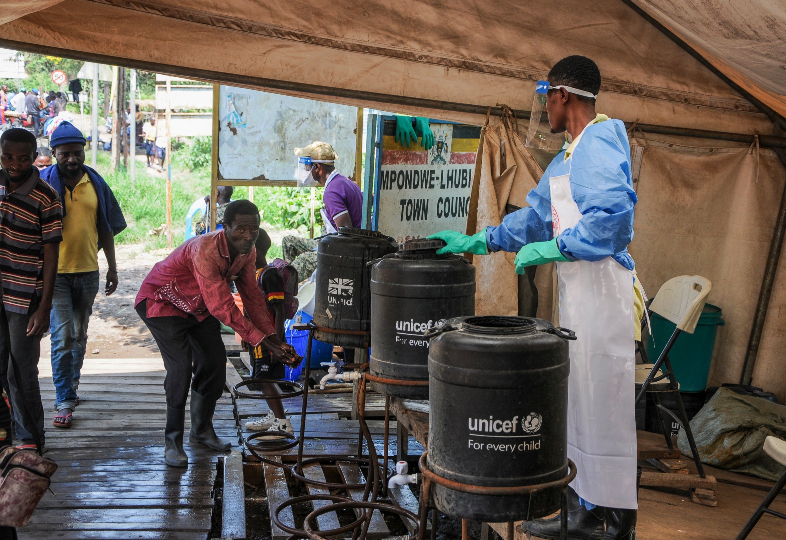FILE - In this Friday, June 14, 2019 file photo, people coming from Congo wash their hands with chlorinated water to prevent the spread of Ebola infection, at the Mpondwe border crossing with Congo. Ugandan health authorities on Thursday, Aug. 29, 20
