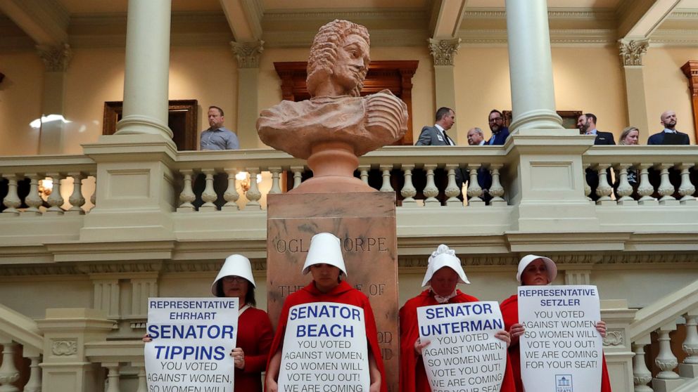 Women hold signs to protest HB 481 at the state Capitol, Tuesday, April 2, 2019, in Atlanta. HB 481, which would ban most abortions after a fetal heart beat is detected, has past both the House and the Senate and awaits a signature from Gov. Brian Ke