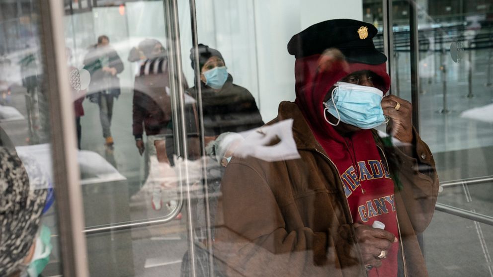 A patient adjusts his face mask as he leaves a COVID-19 vaccination site inside the Jacob K. Javits Convention Center, Wednesday, Feb. 3, 2021, in the Manhattan borough of New York. (AP Photo/John Minchillo)