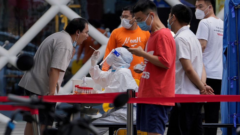 Residents get swabbed during mass COVID-19 testing in the Chaoyang district in Beijing, Tuesday, June 14, 2022. Authorities ordered another round of three days of mass testing for residents in the Chaoyang district following the detection of hundreds