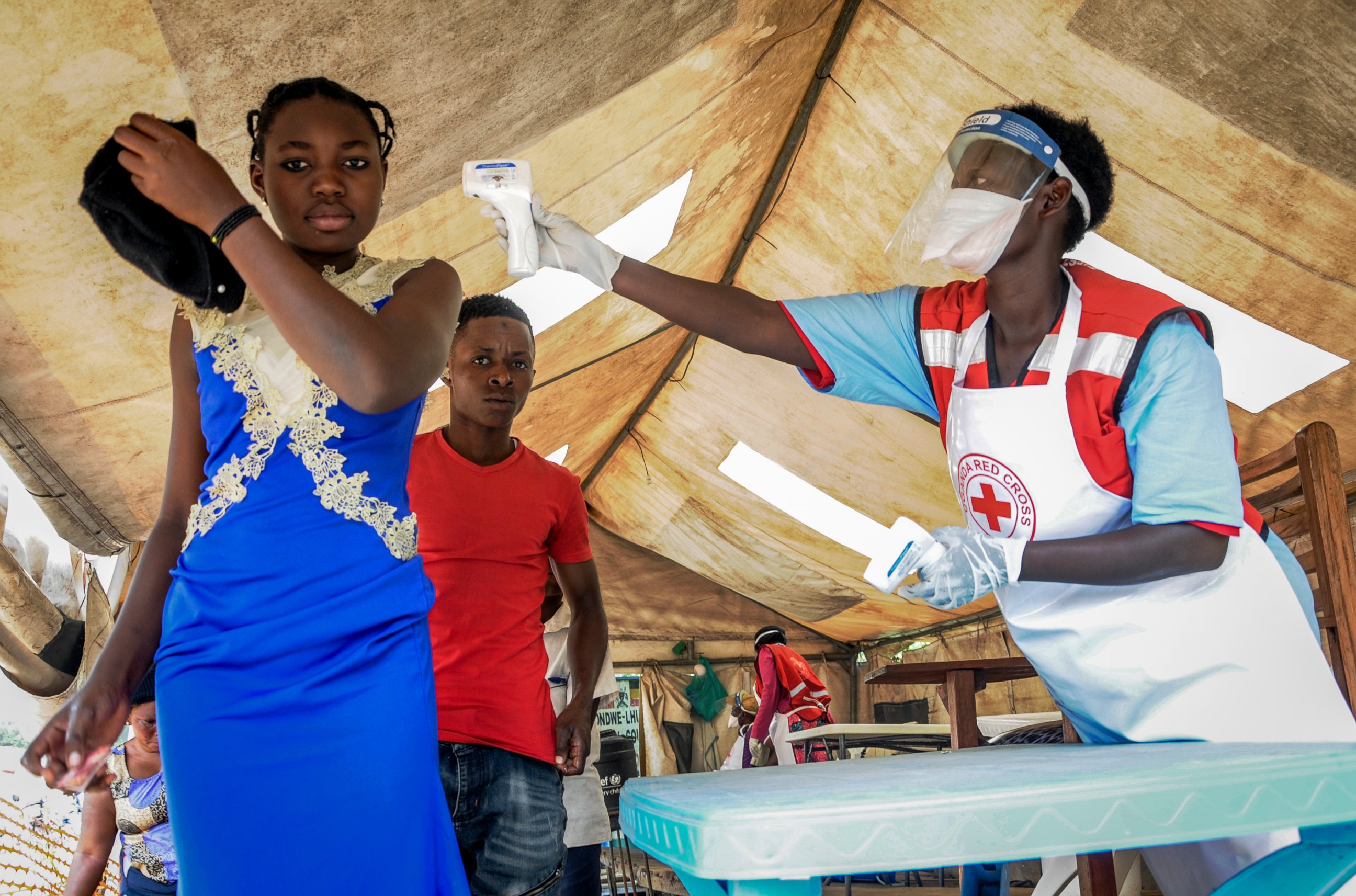 FILE - In this Friday, June 14, 2019 file photo, people coming from Congo have their temperature measured to screen for symptoms of Ebola, at the Mpondwe border crossing with Congo, in western Uganda. Ugandan health authorities on Thursday, Aug. 29, 