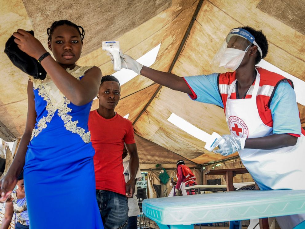 FILE - In this Friday, June 14, 2019 file photo, people coming from Congo have their temperature measured to screen for symptoms of Ebola, at the Mpondwe border crossing with Congo, in western Uganda. Ugandan health authorities on Thursday, Aug. 29, 