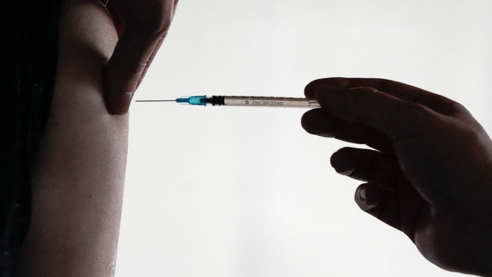 FILE - A doctor injects vaccination against the coronavirus and the COVID-19 disease to a man in Berlin, Germany, Wednesday, Jan. 5, 2022. Germany’s top court has approved rules requiring that health workers be vaccinated against COVID-19. The Consti