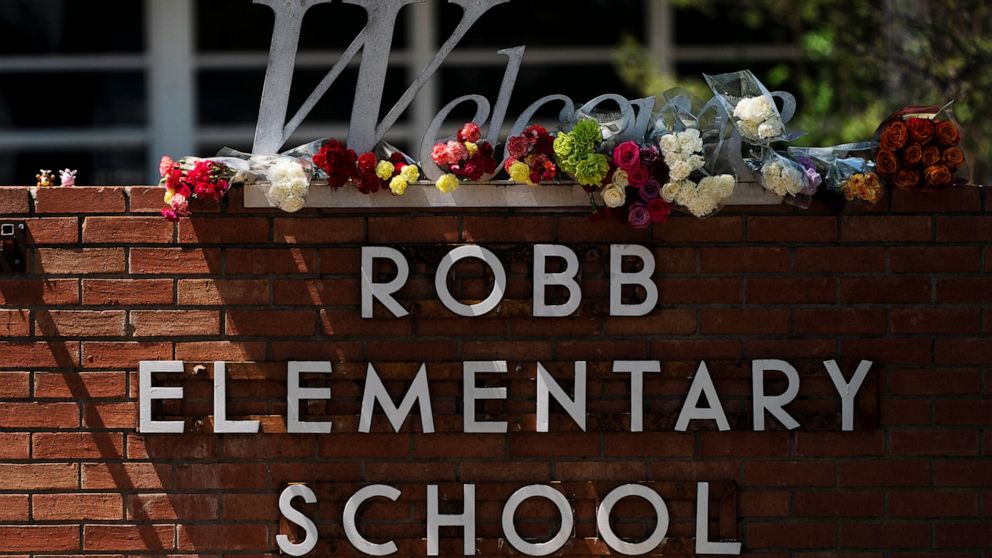 FILE - Flowers are placed around a welcome sign outside Robb Elementary School in Uvalde, Texas, Wednesday, May 25, 2022, to honor the victims killed in a shooting at the school a day earlier. In the aftermath of the elementary school massacre in Uva