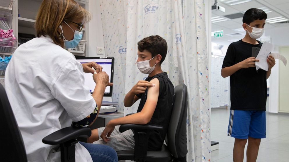 FILE - In this June 6, 2021 file photo, a youth receives a Pfizer-BioNTech COVID-19 vaccine in the central Israeli city of Rishon LeZion. The pharmaceuticals Pfizer and BioNTech say they have requested that their coronavirus vaccine be licensed for c