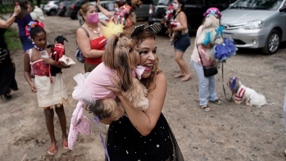Francisca poses with her pet dog Eva during the annual dog Carnival parade in Rio de Janeiro, Brazil, Saturday, Feb. 13, 2021. Rio's Carnival festivities were canceled due to the new coronavirus pandemic, but pet lovers from around the city gathered 