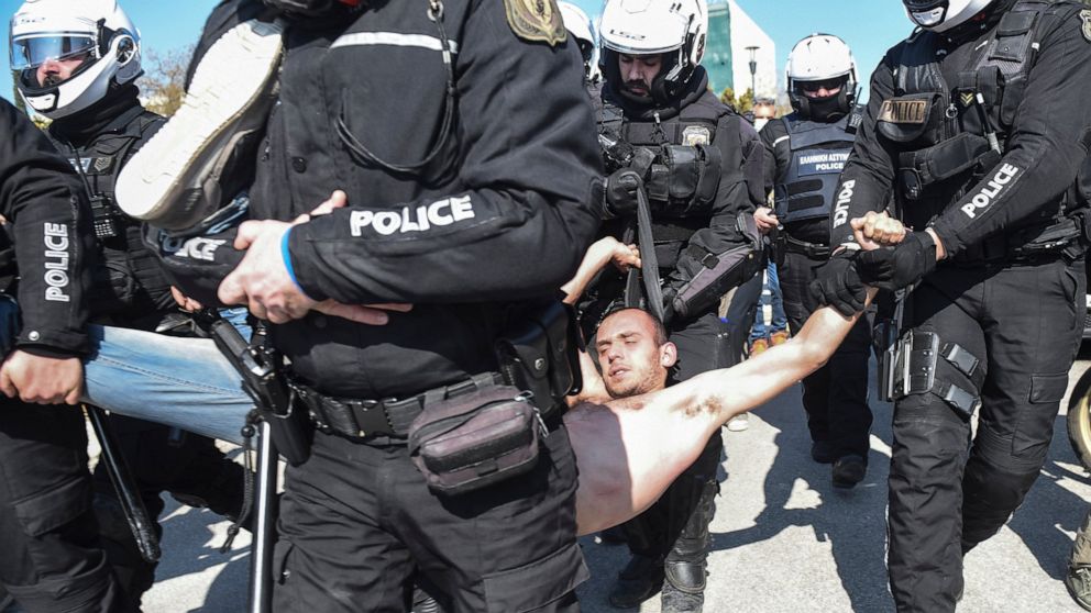 Police detain a protester at the University of Thessaloniki in northern Greece, on Monday, Feb. 22, 2021. Police clashed with protesters and detained more than 30 people in Greece's second-largest city Monday during a demonstration against a new camp