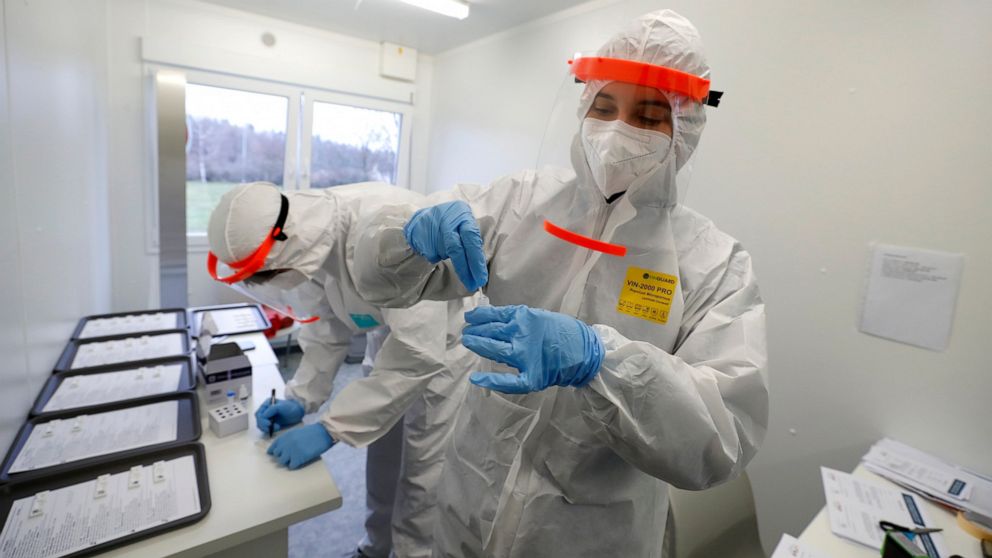 FILE- Medical workers examine the rapid antigen tests for the coronavirus in Prague, Czech Republic, Wednesday, Dec. 16, 2020. Czech Republic's Health Minister Vlastimil Valek said Friday Jan. 14, 2022 that the new Czech government will allow some pe
