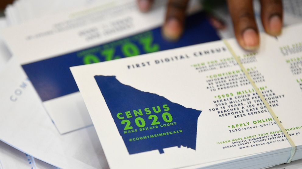 FILE - In this Aug. 13, 2019, file photo, a worker gets ready to pass out instructions on how to fill out the 2020 census during a town hall meeting in Lithonia, Ga. The U.S. Census Bureau on Wednesday, March 18, 2020, suspended field operations for 