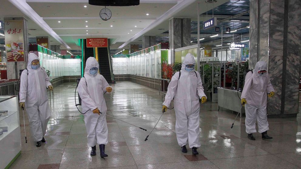 FILE - In this Dec. 28, 2020, file photo, staff of the Pyongyang Department Store No. 1 disinfect the store to help curb the spread of the coronavirus before it opens in Pyongyang, North Korea. The World Health Organization says it has started a proc