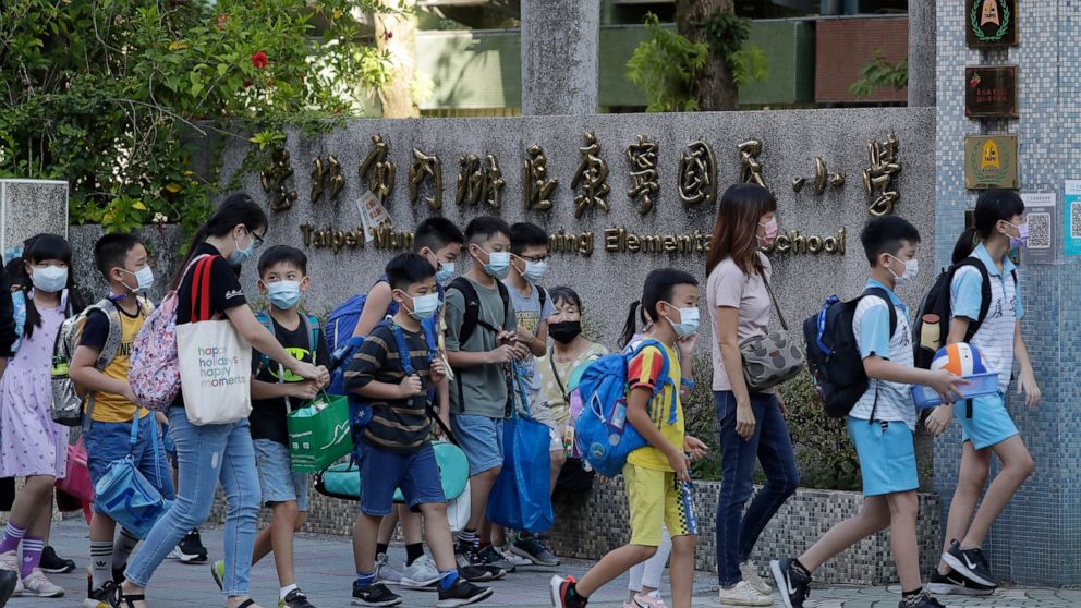 The Latest: Taiwan schools open with masks, plastic dividers