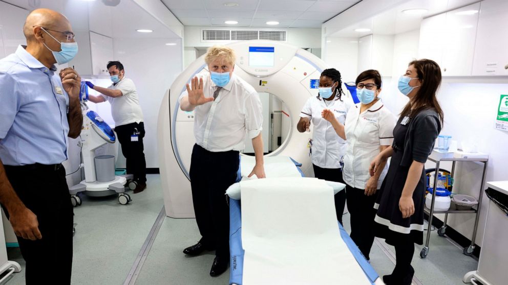 Britain's Prime Minister Boris Johnson, centre, gestures, during a visit to Finchley Memorial Hospital, in North London, Tuesday, Jan. 18, 2022. (Ian Vogler, Pool Photo via AP)