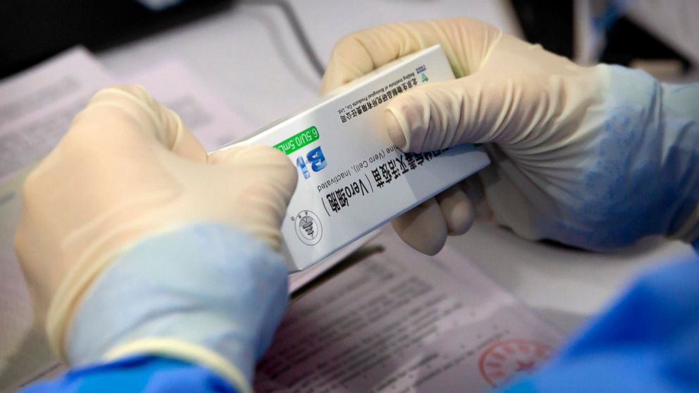 A worker opens a package of coronavirus vaccine made by a Sinopharm subsidiary during a COVID-19 vaccination session for resident foreign journalists at a vaccination center in Beijing, Tuesday, March 23, 2021. Chinese medical firm Sinovac said its C