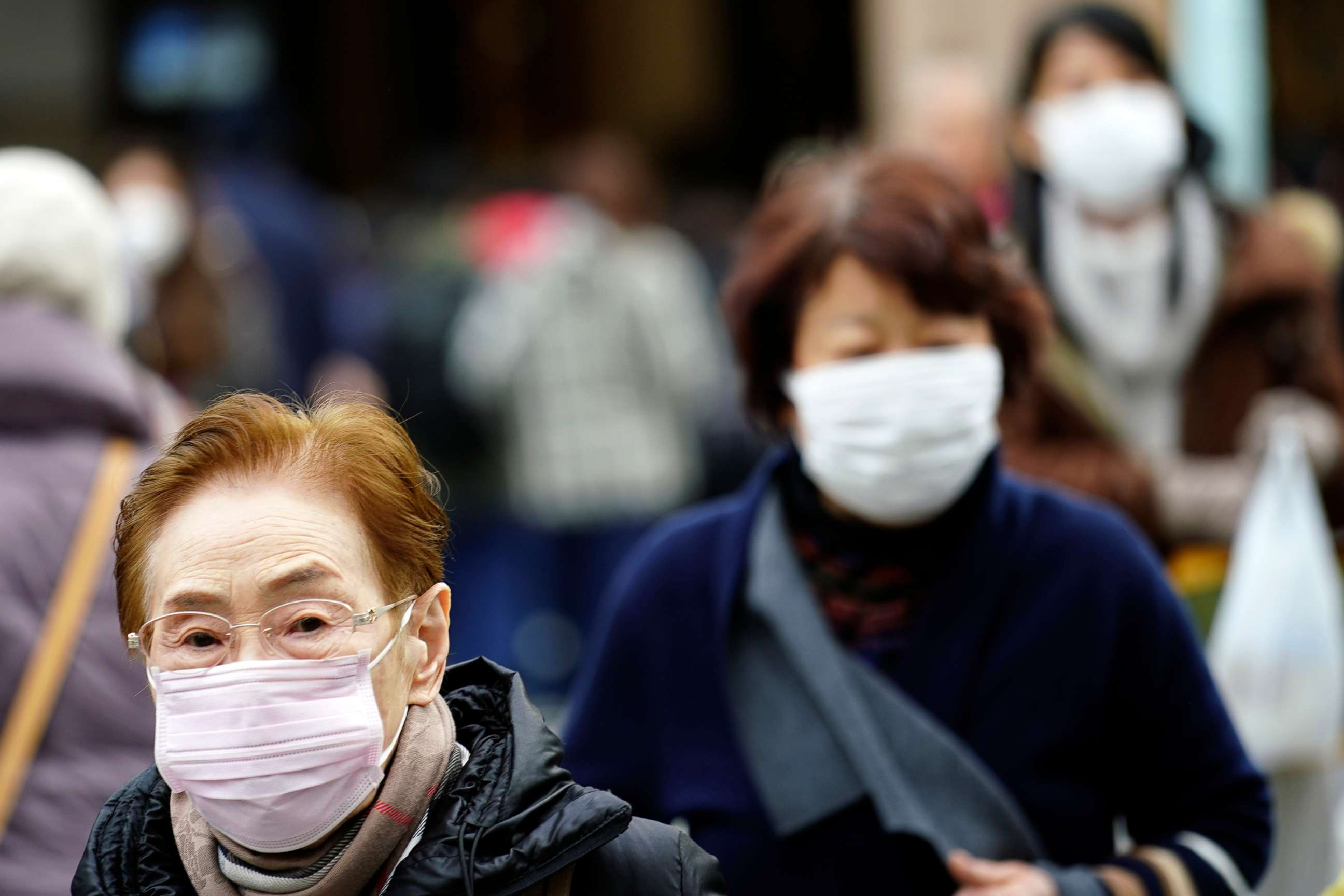 PHOTO: Pedestrian wear protective masks as they walk on a shopping district in Tokyo, Jan. 16, 2020. 