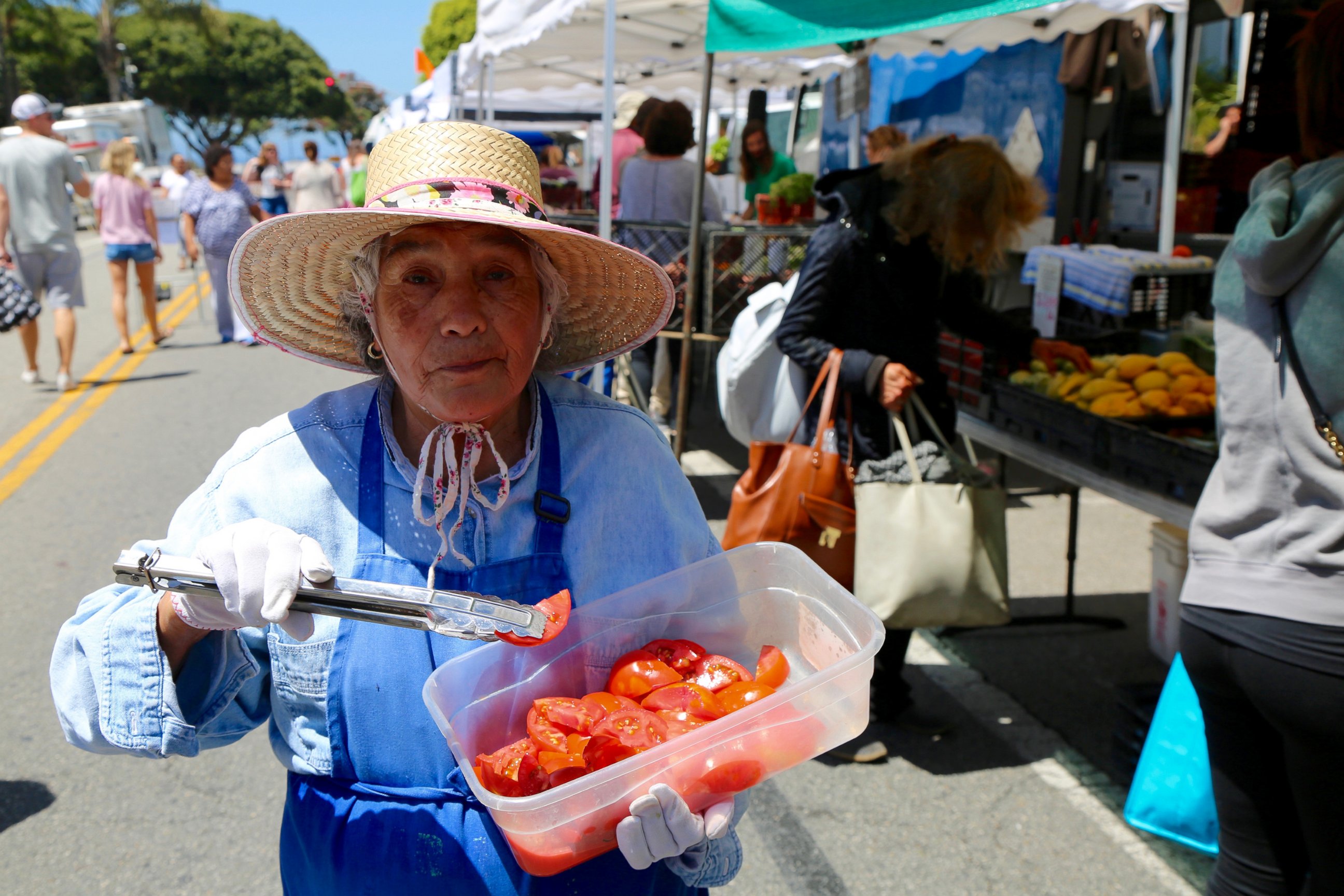 PHOTO: A woman offers samples of tomatoes at the Santa Monica Farmers' Market in Los Angeles, June 14, 2017.