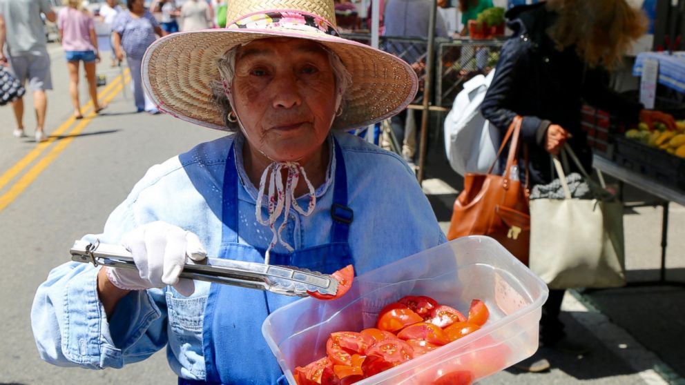 PHOTO: A woman offers samples of tomatoes at the Santa Monica Farmers' Market in Los Angeles, June 14, 2017.