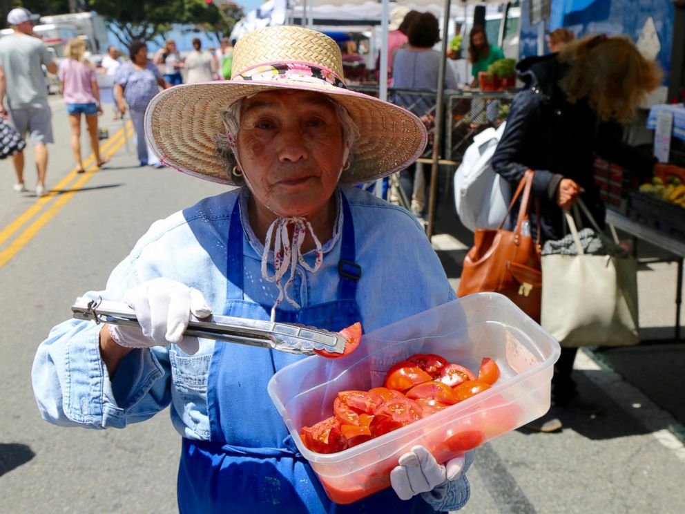 PHOTO: A woman offers samples of tomatoes at the Santa Monica Farmers Market in Los Angeles, June 14, 2017.