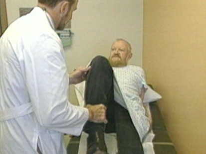 A picture of a docter bending someones knee.