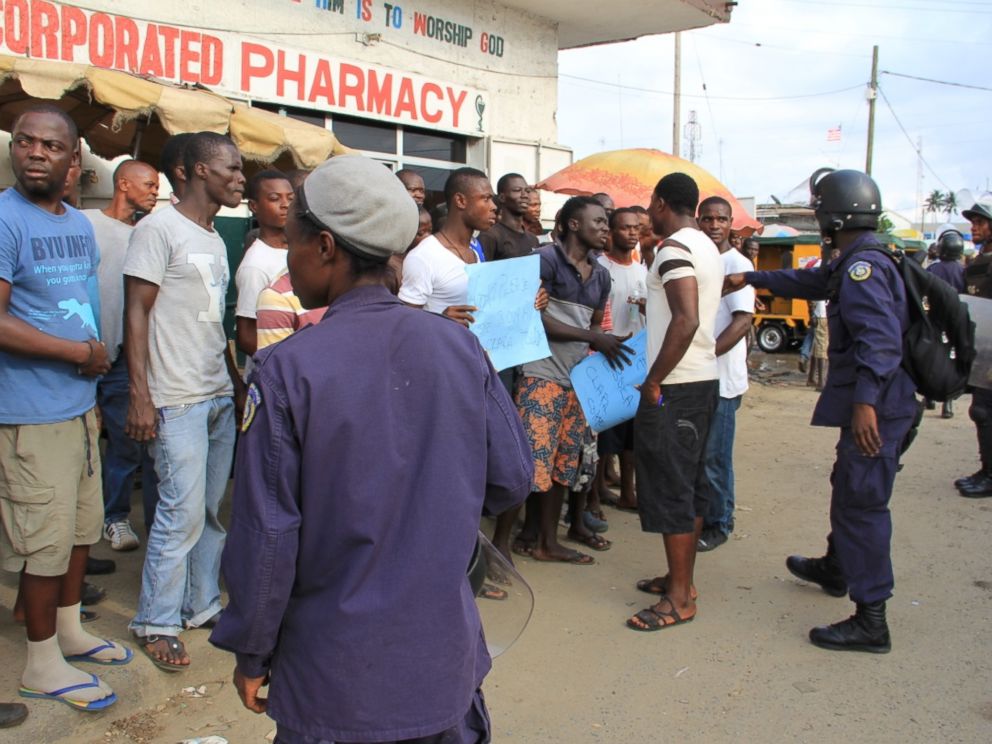 PHOTO: Liberian police in riot gear ask protesters in the Clara Town section of Monrovia to step back onto the sidewalk.