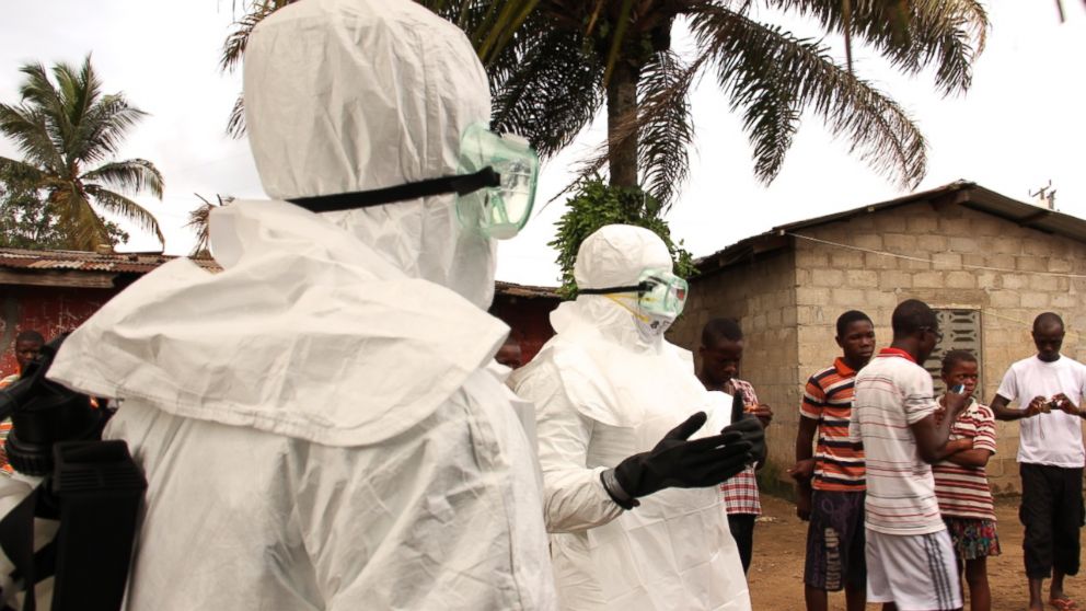 After failing to convince three suspected Ebola victims to go with them to an Ebola treatment center in Monrovia, Liberia, health care workers speak to a small crowd that has gathered.