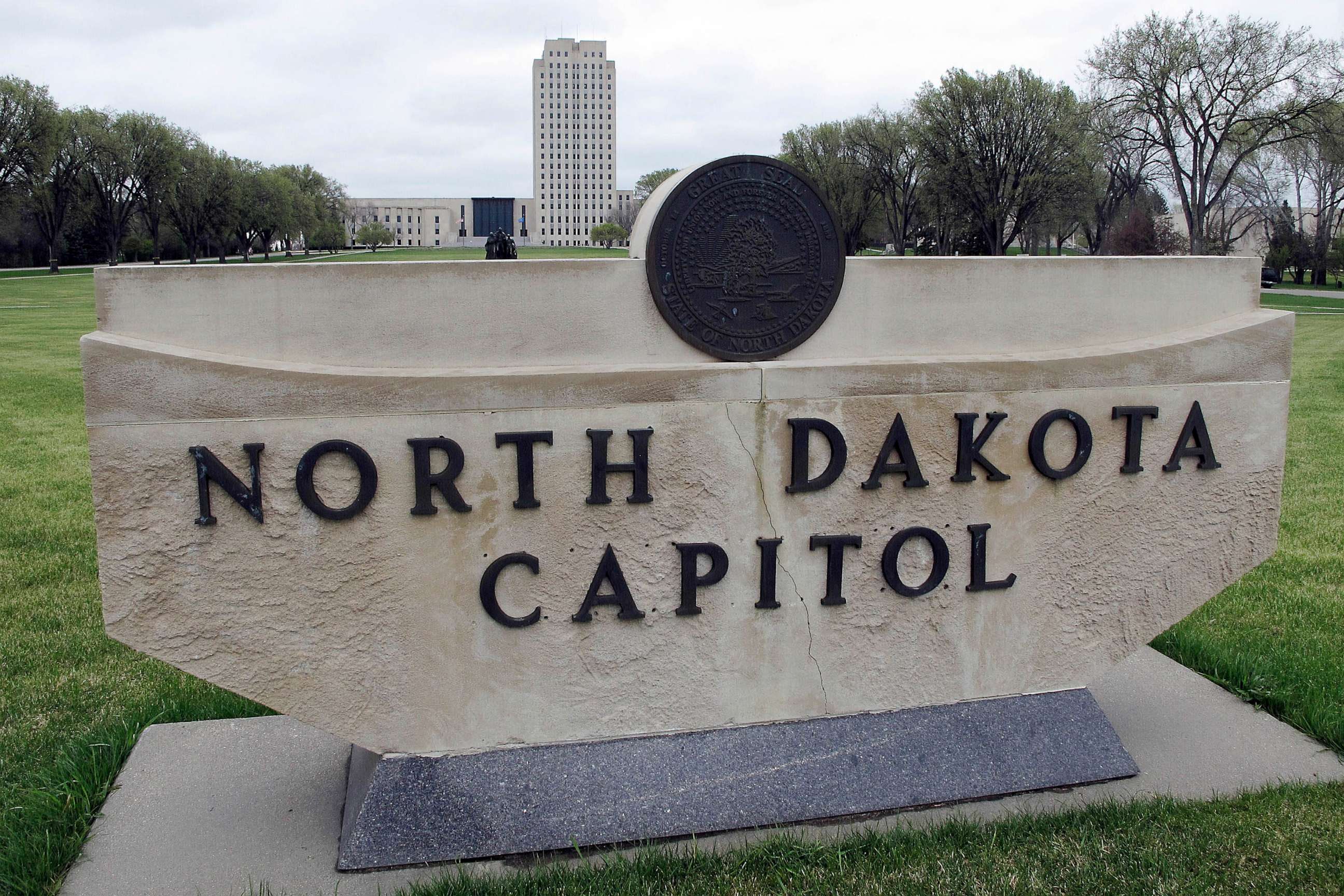 PHOTO: FILE - The North Dakota Capitol tower rises in the background behind a stone sign, April 19, 2012, in Bismarck, N.D.